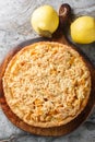 Fresh Quince crumble tart closeup on the wooden board. Vertical top view