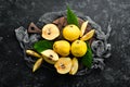 Fresh quince fruits on a wooden board. Top view.