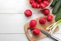 Fresh radish. Spring fresh vegetables radishes, cucumber, green onions and greens on a white wooden table. ingredients for cooking Royalty Free Stock Photo