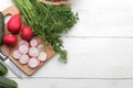 Fresh radish. Spring fresh vegetables radishes, cucumber, green onions and greens on a white wooden table. ingredients for cooking Royalty Free Stock Photo