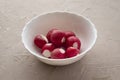 fresh radishes in a white cup on the table