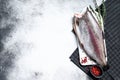 Fresh rainbow trout fish marinated with salt and thyme. Gray background. Top view. Copy space