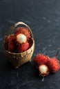 Fresh Rambutan, Summer Fruit in a Basket on a Black Background Royalty Free Stock Photo