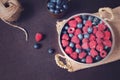 Fresh raspberries and blueberries dark picture with copy space on left. Fresh fruits, berries in an old copper cup, bowl. Dark Sty Royalty Free Stock Photo