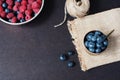 Fresh raspberries and blueberries dark picture with copy space on left. Fresh fruits, berries in an old copper cup, bowl. Dark Sty Royalty Free Stock Photo