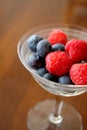 Fresh Raspberries and Blueberries in a Vintage Champagne Glass Royalty Free Stock Photo