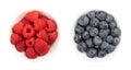 Fresh raspberries and blueberries, whole and ripe fruits, in white bowls