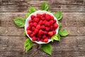 Fresh raspberries with green leaves on wooden background. Top view Royalty Free Stock Photo