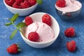 Fresh raspberries with mint and homemade ice cream in a white cup on a blue background. Stainless steel spoon for ice cream balls Royalty Free Stock Photo