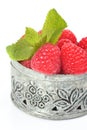 Fresh raspberries in small delicate metal casket over white