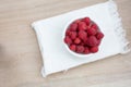 Fresh Raspberries in white bowl with white napkin Royalty Free Stock Photo