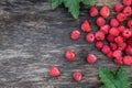 Fresh raspberries on wooden background with green leaves, top view, copy space. Royalty Free Stock Photo