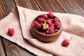 Fresh raspberries in wooden bowl on brown table. Red ripe raspberries, sweet berries Royalty Free Stock Photo