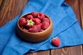 Fresh raspberries in wooden bowl on brown table. Red ripe raspberries, sweet berries Royalty Free Stock Photo