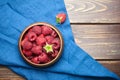 Fresh raspberries in wooden bowl on brown table. Red ripe raspberries, sweet berries Royalty Free Stock Photo