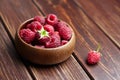 Fresh raspberries in wooden bowl on brown table. Red ripe raspberries, sweet berries Royalty Free Stock Photo