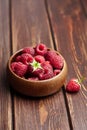 Fresh raspberries in wooden bowl on brown table. Red ripe raspberries, sweet berries Royalty Free Stock Photo