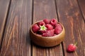 Fresh raspberries in wooden bowl on brown table. Red ripe raspberries, sweet berries Royalty Free Stock Photo