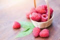 Fresh raspberry in basket and green leaf Close up red ripe raspberries fruit on wooden background