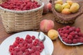 Fresh Raspberry basket, peaches and Apricot in a wicker basket on wooden table