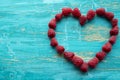 Fresh raspberry fruit, heart shape on a blue background. Royalty Free Stock Photo