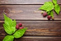 Fresh raspberry, red berries with green leaves on wooden table Royalty Free Stock Photo