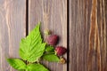 Fresh raspberry, red berries with green leaves on wooden table Royalty Free Stock Photo