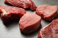 Fresh raw beef cuts on grey table, closeup