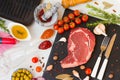 A fresh raw beef entrecote with ingredients to cooking tasty dinner, red wine and wine glasses, top view. Royalty Free Stock Photo