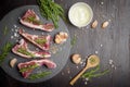 Fresh raw beef and ingredients steak on black stone board over black wooden table