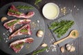 Fresh raw beef and ingredients steak on black stone board over black wooden table