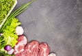 Fresh raw beef marble meat with vegetables and sprouts of flax microgrid on a dark stone background