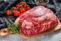 Fresh raw beef marbled steak. Chuck eye roll on a cleaver. Gray background. Top view Royalty Free Stock Photo