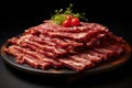 Fresh raw beef ribeye slices on dark plate