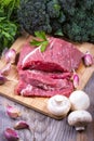 Fresh raw beef steak with mushrooms, olives, spices, broccoli and parsley. Healthy food