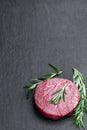 Fresh raw beef steak with rosemary stick on black stone background Royalty Free Stock Photo