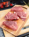 Fresh raw beef steaks on a wooden cutting board