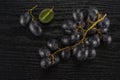 Fresh raw black grape on black wood