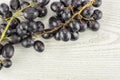 Fresh raw black grape on grey wood