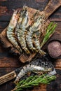 Fresh Raw black tiger prawns, shrimps on a cutting board. Dark wooden background. Top view Royalty Free Stock Photo