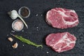 Fresh raw boneless pork neck slices on black stone background.