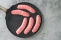 Fresh raw bratwurst pork sausages on a frying pan close-up on the kitchen table, flat lay, copy space for the text Royalty Free Stock Photo