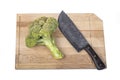 Fresh raw broccoli, cutting board made of wood on a white background. a large knife for cutting in the kitchen