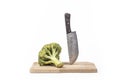 Fresh raw broccoli, cutting board made of wood on a white background. a large knife for cutting in the kitchen Royalty Free Stock Photo