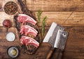Fresh raw butchers lamb beef cutlets on chopping board with vintage meat hatchets on wooden background.Salt, pepper and oil in Royalty Free Stock Photo
