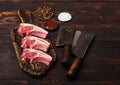 Fresh raw butchers lamb beef cutlets on chopping board with vintage meat hatchets on wooden background.Salt, pepper and oil in Royalty Free Stock Photo