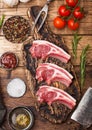 Fresh raw butchers lamb beef cutlets on chopping board with vintage meat hatchets on wooden background.Salt, pepper and oil with Royalty Free Stock Photo
