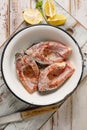 Fresh, raw carp fish slices seasoned sea salt, lemon juice and spices in enamel bowl,