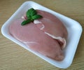 Raw chicken breast fillets skinned with basil leaves