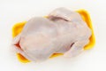 Fresh raw Chicken carcass or broiler chicken on a yellow plastic pallet on white background